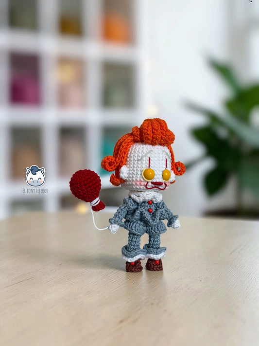 Amigurumi de Pennywise inspirado en IT, un patrón PDF de crochet con estilo Funko y su icónico globo rojo, perfecto para fans del cine de terror y la decoración de Halloween.
