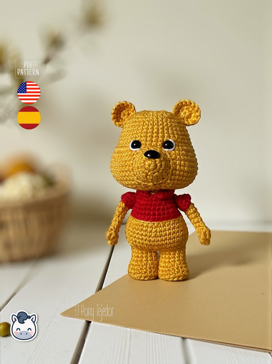 Patrón de ganchillo Amigurumi de Winnie the Pooh con camiseta roja, tejido a mano con hilo de algodón, diseño clásico y estilo kawaii.