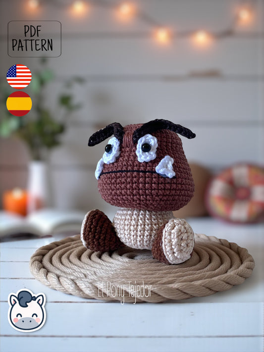 ¡Este pequeño enemigo del Mundo Champiñón ha decidido cambiar su destino y convertirse en el más adorable del juego! Con este patrón digital de amigurumi podrás tejer paso a paso tu propio Goomba, perfecto para fans de Nintendo, Super Mario Bros y los videojuegos retro. 🍄 Patrón ideal para quienes aman el estilo geek, los clásicos de consola y los muñecos de colección hechos a mano.