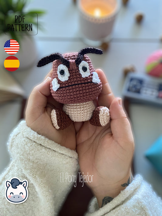¡Este pequeño enemigo del Mundo Champiñón ha decidido cambiar su destino y convertirse en el más adorable del juego! Con este patrón digital de amigurumi podrás tejer paso a paso tu propio Goomba, perfecto para fans de Nintendo, Super Mario Bros y los videojuegos retro. 🍄 Patrón ideal para quienes aman el estilo geek, los clásicos de consola y los muñecos de colección hechos a mano.