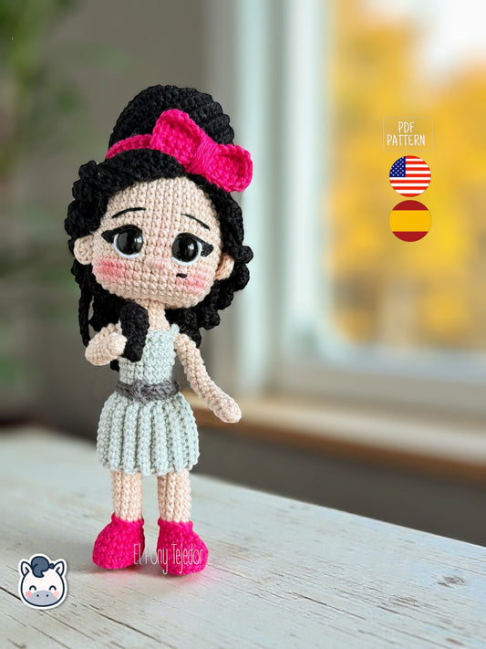 Patrón de ganchillo amigurumi inspirado en Amy Winehouse, muñeca tejida a crochet con peinado característico y vestido azul.
Amy Winehouse inspired crochet amigurumi pattern, handmade doll with iconic hairstyle and blue dress.