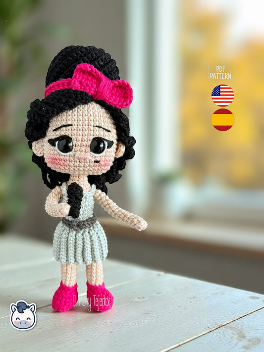 Patrón de ganchillo amigurumi inspirado en Amy Winehouse, muñeca tejida a crochet con peinado característico y vestido azul.
Amy Winehouse inspired crochet amigurumi pattern, handmade doll with iconic hairstyle and blue dress.