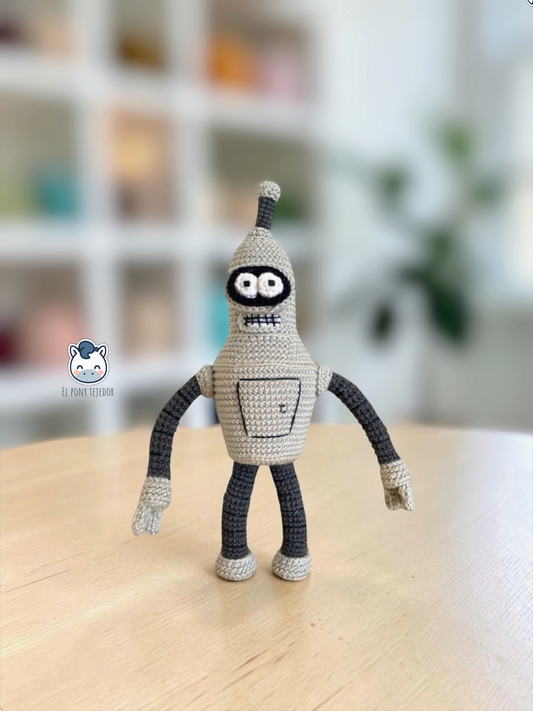 Amigurumi de Bender hecho a mano a crochet, inspirado en Futurama, con su característico cuerpo gris de robot, antena, grandes ojos y sonrisa de dientes cuadrados. Patrón PDF de ganchillo ideal para fans de Futurama, amantes de la ciencia ficción y coleccionistas de personajes tejidos.