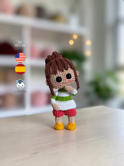 Amigurumi de Chihiro inspirado en El Viaje de Chihiro, con su característica coleta, jersey a rayas y pantalones rosas. Un patrón de crochet perfecto para fans de Studio Ghibli, amantes del anime japonés, coleccionistas geek y aficionados a los amigurumis hechos a mano.