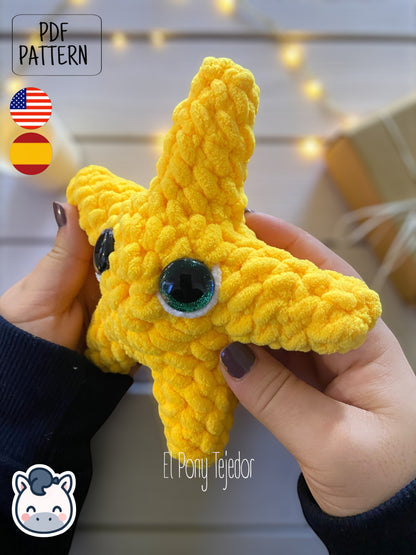 Patrón de ganchillo amigurumi de una estrella de Navidad amarilla tejida en lana de terciopelo con ojos grandes y brillantes. EN: Crochet amigurumi pattern of a yellow Christmas star made with velvet yarn and big glittery eyes.