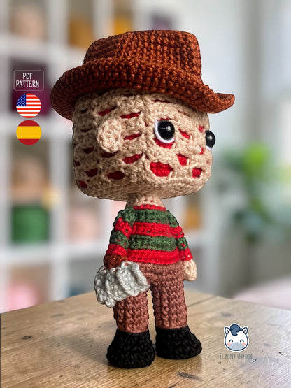 Amigurumi de Freddy Krueger tejido a crochet con sombrero marrón y jersey rojo y verde, patrón digital PDF para fans del cine de terror y muñecos estilo Funko