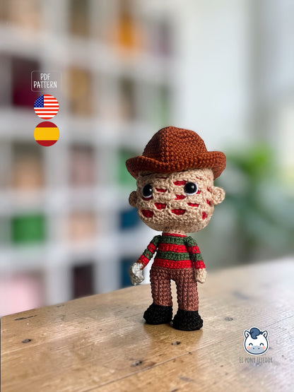 Amigurumi de Freddy Krueger tejido a crochet con sombrero marrón y jersey rojo y verde, patrón digital PDF para fans del cine de terror y muñecos estilo Funko