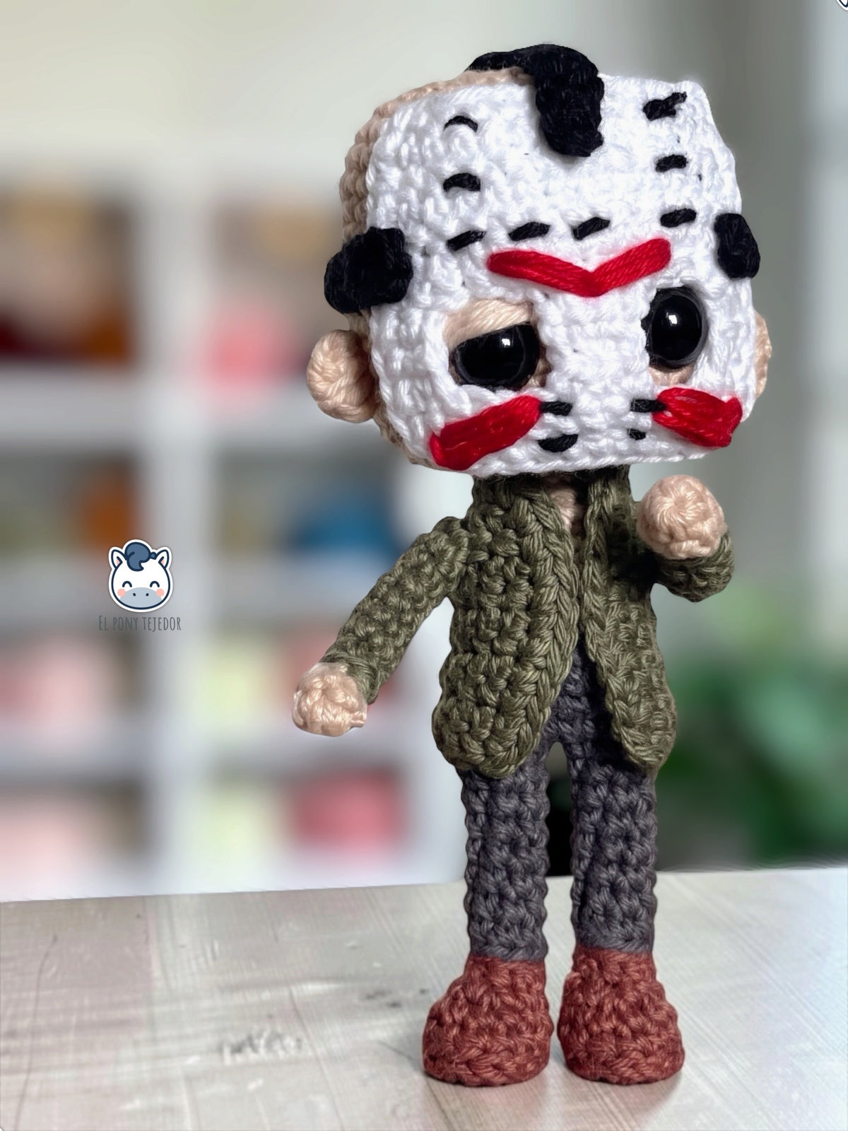Amigurumi de Jason Voorhees hecho a mano a ganchillo, inspirado en Viernes 13, con su icónica máscara blanca de hockey, chaqueta verde y pantalones oscuros. Patrón PDF de crochet ideal para Halloween y coleccionistas del cine de terror.