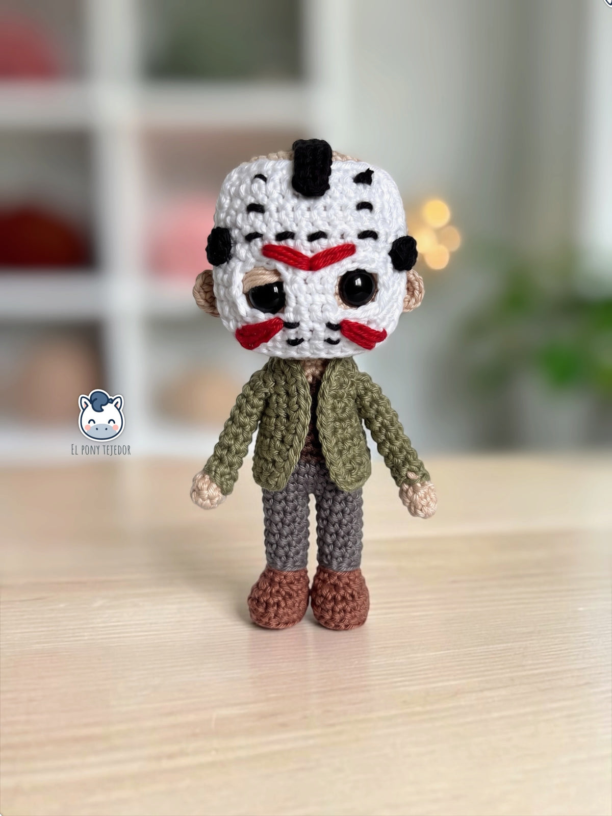 Amigurumi de Jason Voorhees hecho a mano a ganchillo, inspirado en Viernes 13, con su icónica máscara blanca de hockey, chaqueta verde y pantalones oscuros. Patrón PDF de crochet ideal para Halloween y coleccionistas del cine de terror.