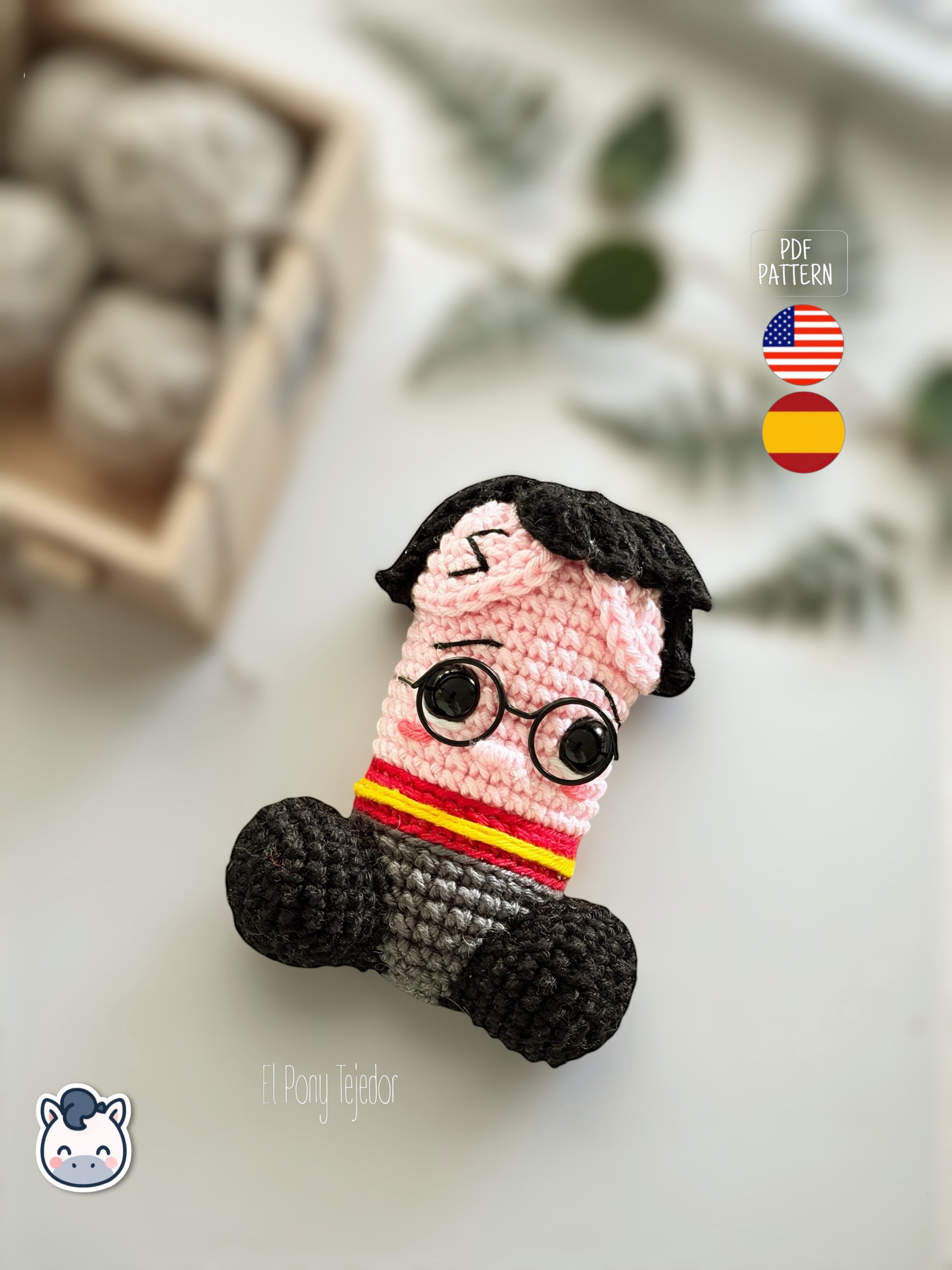 Patrón de ganchillo amigurumi pene inspirado en Harry Potter con gafas redondas, bufanda roja y amarilla y detalles bordados, diseño divertido y original.
