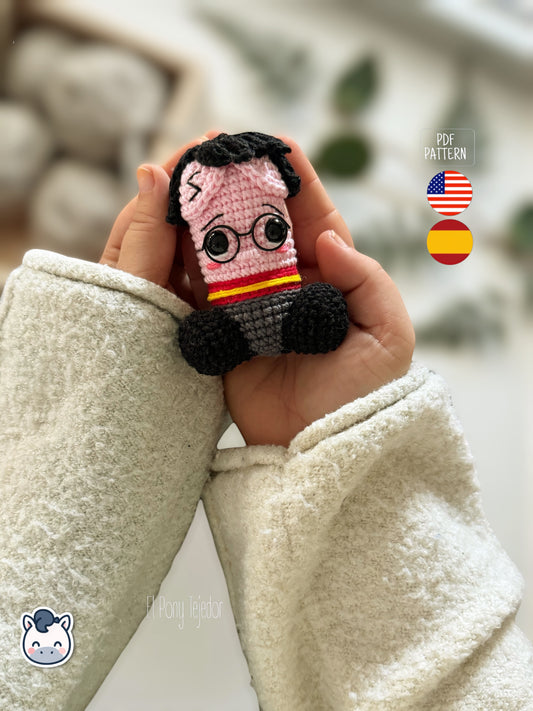 Patrón de ganchillo amigurumi pene inspirado en Harry Potter con gafas redondas, bufanda roja y amarilla y detalles bordados, diseño divertido y original.