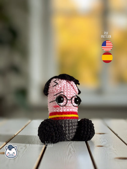 Patrón de ganchillo amigurumi pene inspirado en Harry Potter con gafas redondas, bufanda roja y amarilla y detalles bordados, diseño divertido y original.