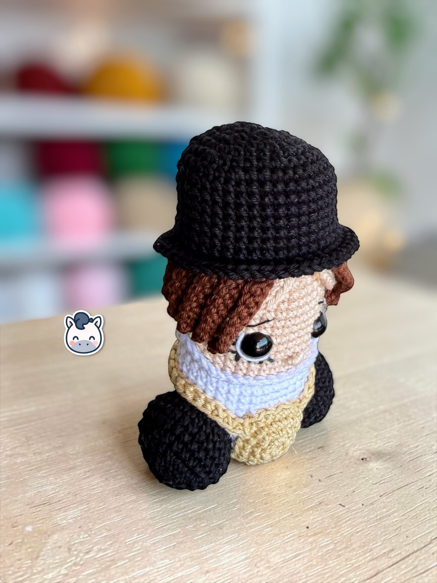 Muñeco amigurumi de Pene hecho a mano a crochet, inspirado en el personaje de La Naranja Mecánica. Peluche artesanal tejido con hilo de algodón, con sombrero negro y detalles característicos de la película. Ideal para coleccionistas de cine, decoración geek y amantes de las películas de culto.