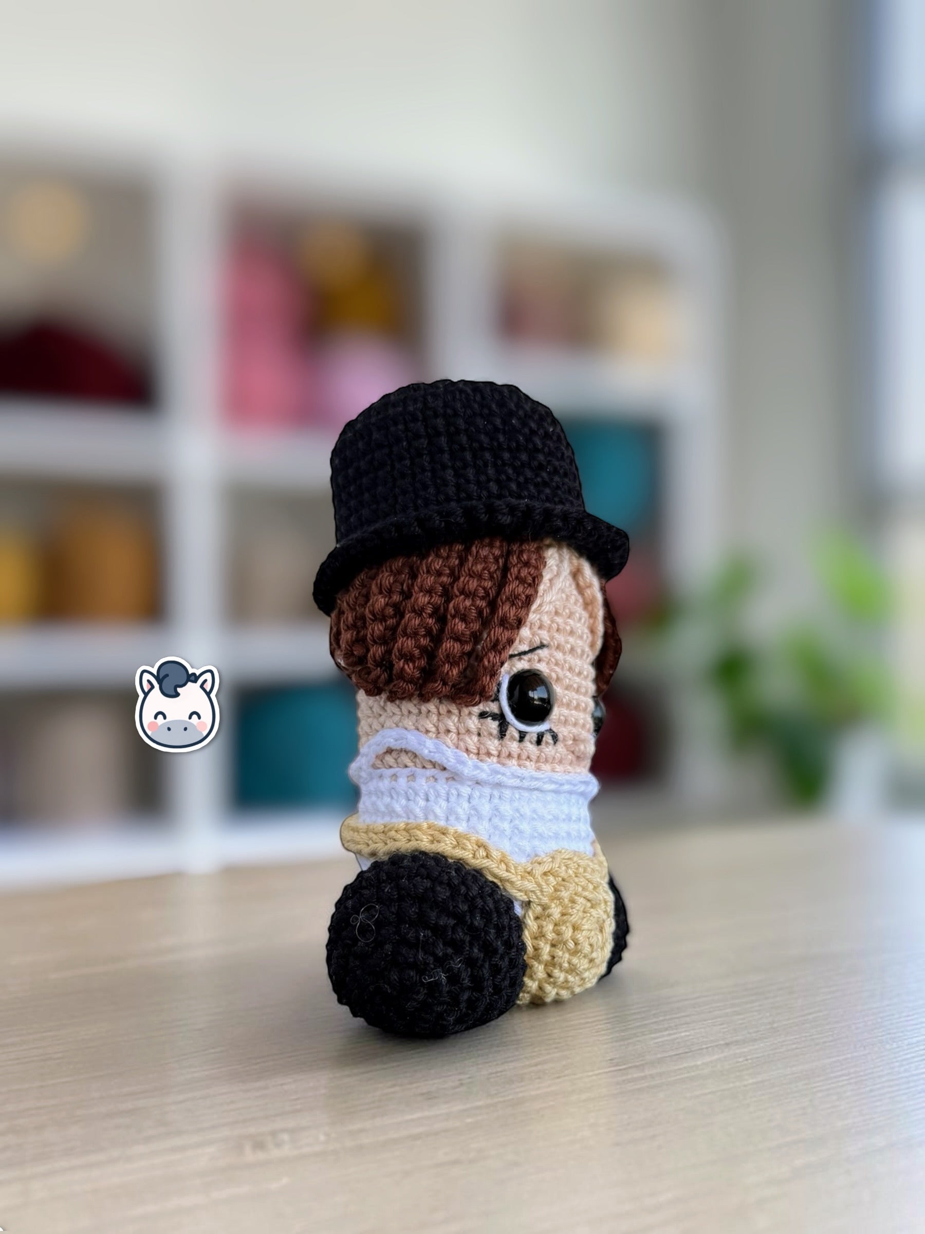 Muñeco amigurumi de Pene hecho a mano a crochet, inspirado en el personaje de La Naranja Mecánica. Peluche artesanal tejido con hilo de algodón, con sombrero negro y detalles característicos de la película. Ideal para coleccionistas de cine, decoración geek y amantes de las películas de culto.