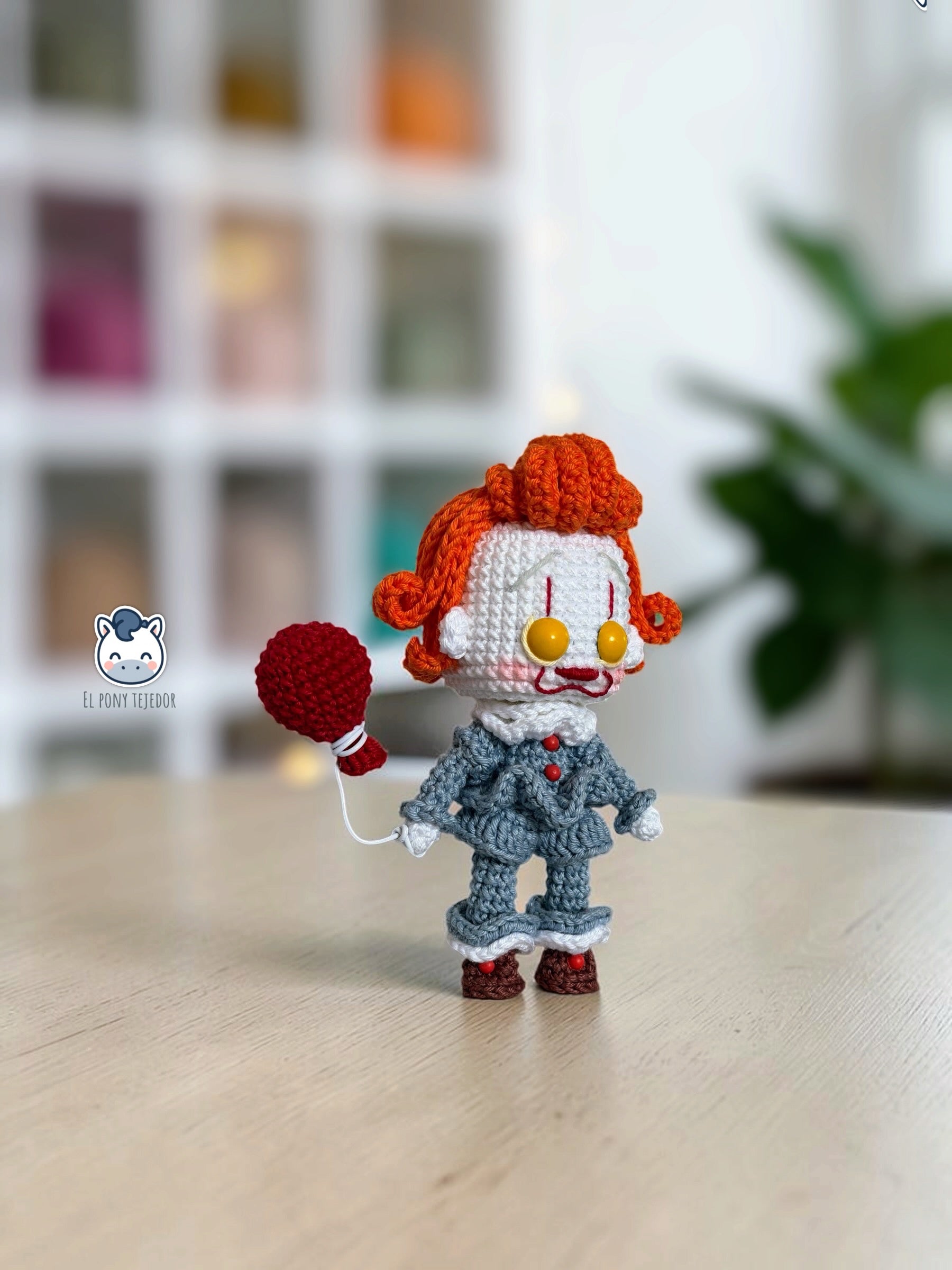 Amigurumi de Pennywise inspirado en IT, un patrón PDF de crochet con estilo Funko y su icónico globo rojo, perfecto para fans del cine de terror y la decoración de Halloween.