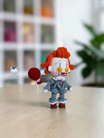 Amigurumi de Pennywise inspirado en IT, un patrón PDF de crochet con estilo Funko y su icónico globo rojo, perfecto para fans del cine de terror y la decoración de Halloween.