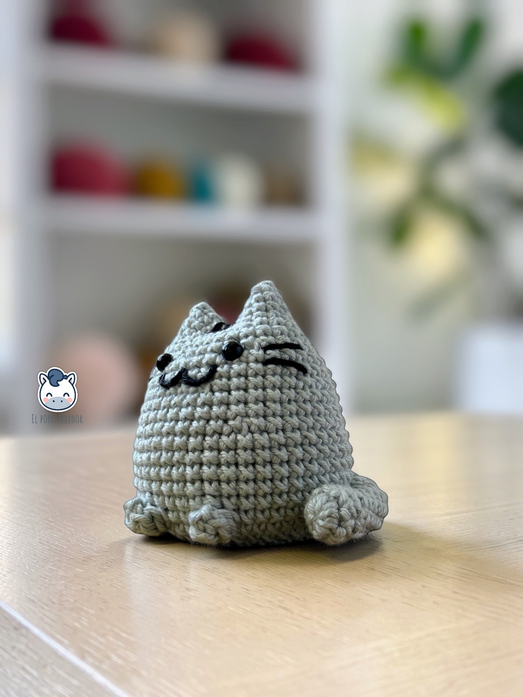 Amigurumi de Pusheen tejido a ganchillo en color gris claro, un patrón de crochet kawaii perfecto para fans de los gatos y amantes de los muñecos handmade estilo plush.