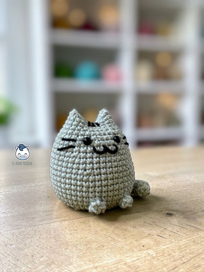 Amigurumi de Pusheen tejido a ganchillo en color gris claro, un patrón de crochet kawaii perfecto para fans de los gatos y amantes de los muñecos handmade estilo plush.