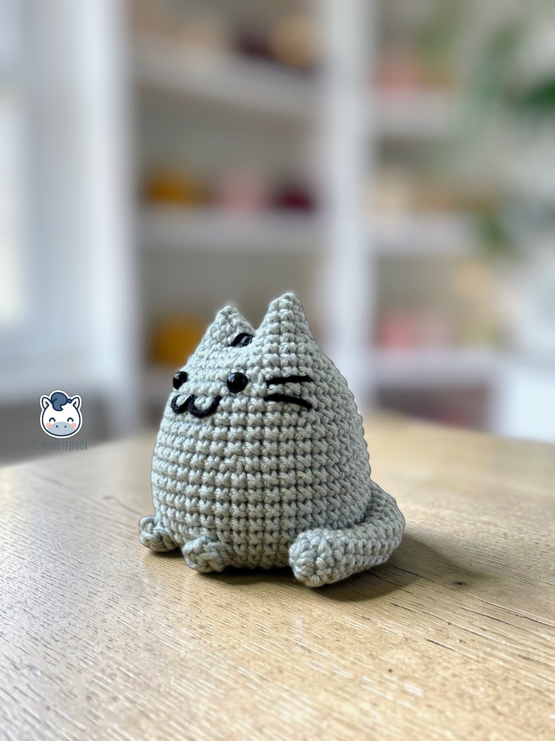 Amigurumi de Pusheen tejido a ganchillo en color gris claro, un patrón de crochet kawaii perfecto para fans de los gatos y amantes de los muñecos handmade estilo plush.