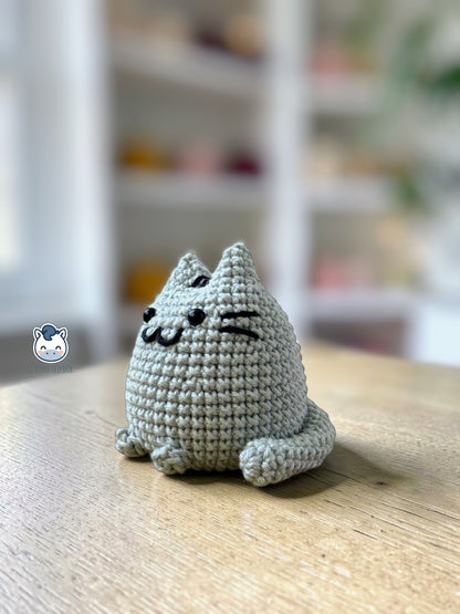Amigurumi de Pusheen tejido a ganchillo en color gris claro, un patrón de crochet kawaii perfecto para fans de los gatos y amantes de los muñecos handmade estilo plush.
