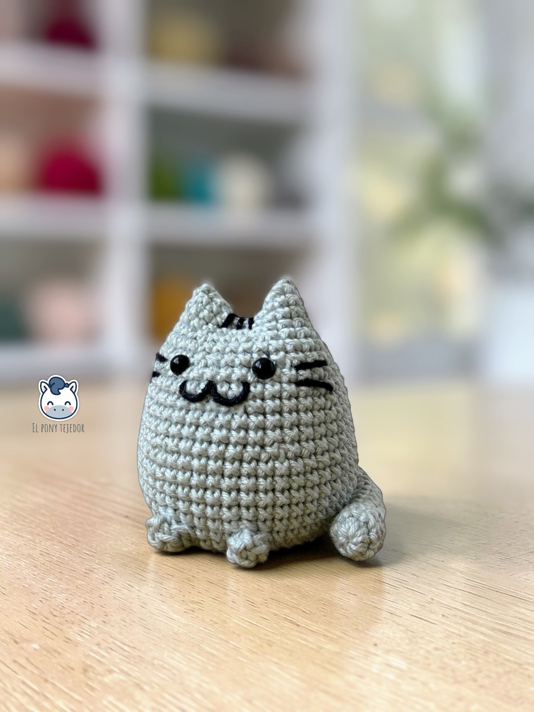 Amigurumi de Pusheen tejido a ganchillo en color gris claro, un patrón de crochet kawaii perfecto para fans de los gatos y amantes de los muñecos handmade estilo plush.