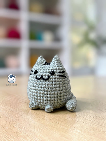 Amigurumi de Pusheen tejido a ganchillo en color gris claro, un patrón de crochet kawaii perfecto para fans de los gatos y amantes de los muñecos handmade estilo plush.