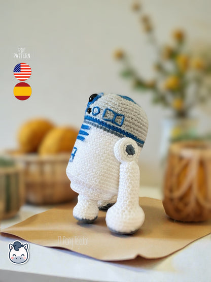 Patrón de ganchillo Amigurumi de R2-D2 tejido en color blanco y azul, inspirado en Star Wars, con detalles bordados y forma compacta.