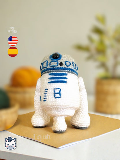 Patrón de ganchillo Amigurumi de R2-D2 tejido en color blanco y azul, inspirado en Star Wars, con detalles bordados y forma compacta.