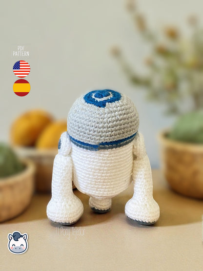 Patrón de ganchillo Amigurumi de R2-D2 tejido en color blanco y azul, inspirado en Star Wars, con detalles bordados y forma compacta.