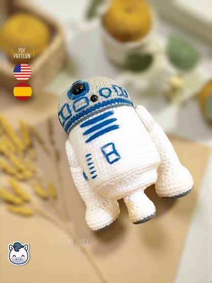Patrón de ganchillo Amigurumi de R2-D2 tejido en color blanco y azul, inspirado en Star Wars, con detalles bordados y forma compacta.