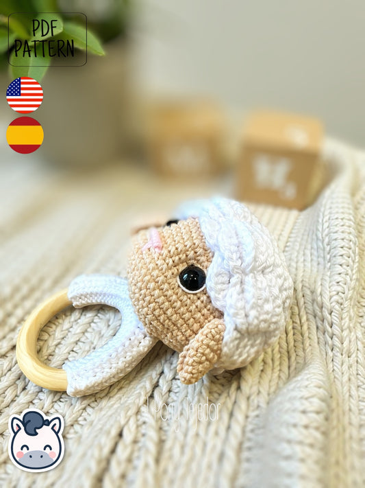 Sonajero de oveja tejido a ganchillo con cabeza de amigurumi blanca y beige sobre aro de madera natural.
Crochet sheep baby rattle with white and beige amigurumi head on a natural wooden ring.