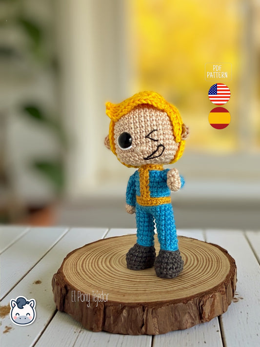 Patrón de ganchillo amigurumi de Vault Boy de Fallout con mono azul y expresión sonriente.
Vault Boy Fallout amigurumi crochet pattern with blue jumpsuit and smiling expression.