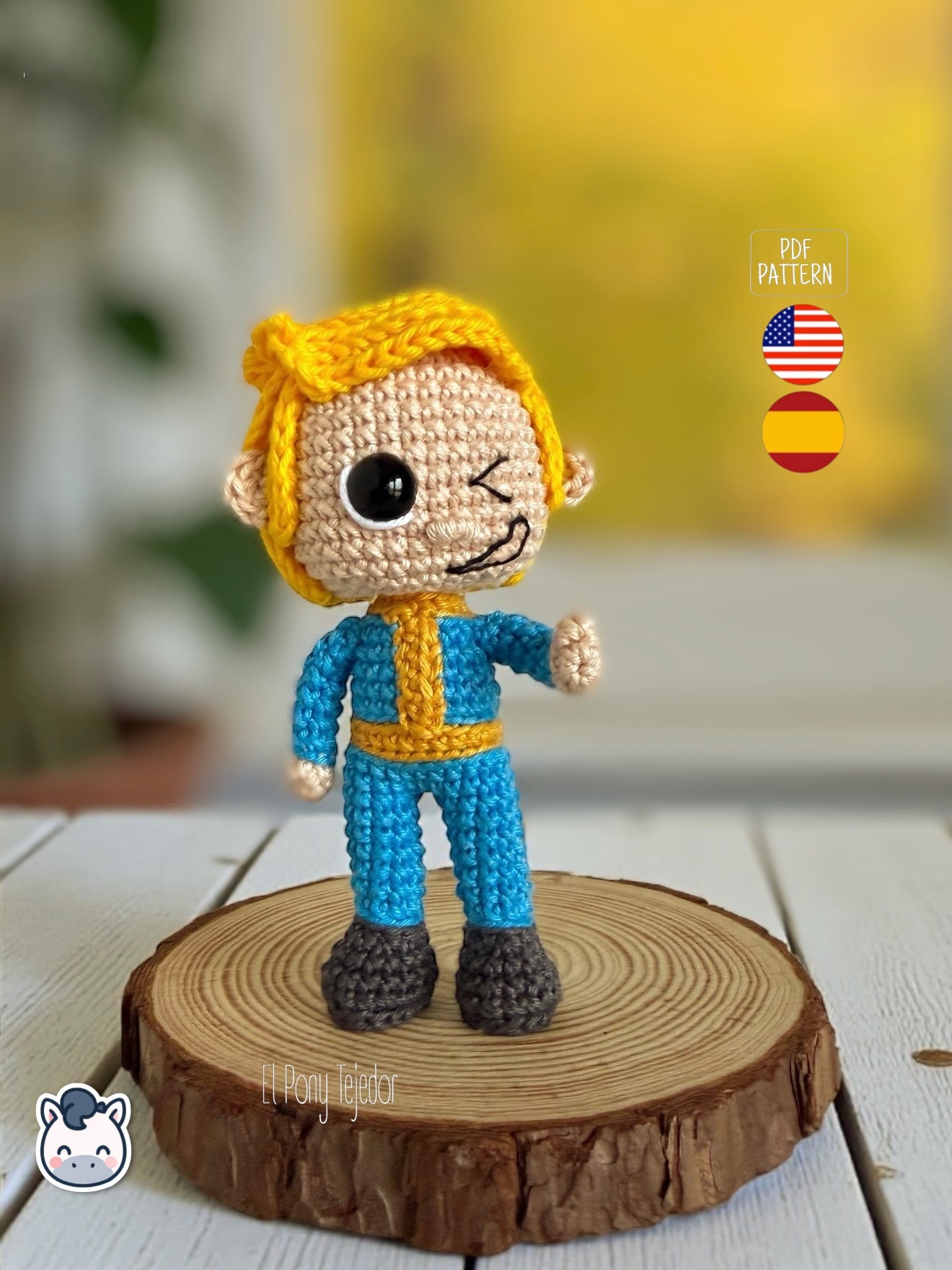 Patrón de ganchillo amigurumi de Vault Boy de Fallout con mono azul y expresión sonriente.
Vault Boy Fallout amigurumi crochet pattern with blue jumpsuit and smiling expression.