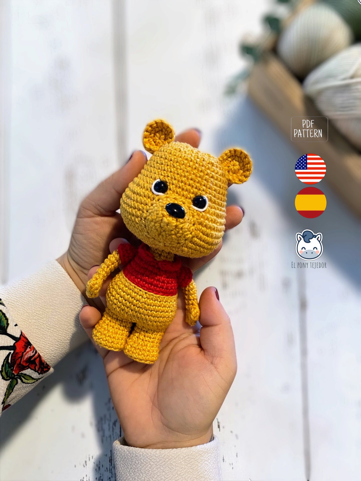 Patrón amigurumi inspirado en Winnie the Pooh tejido a crochet. Osito de ganchillo con camiseta roja, ideal para crear un adorable muñeco amigurumi con patrón PDF paso a paso.
