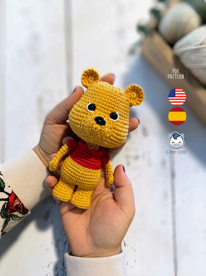 Patrón amigurumi inspirado en Winnie the Pooh tejido a crochet. Osito de ganchillo con camiseta roja, ideal para crear un adorable muñeco amigurumi con patrón PDF paso a paso.