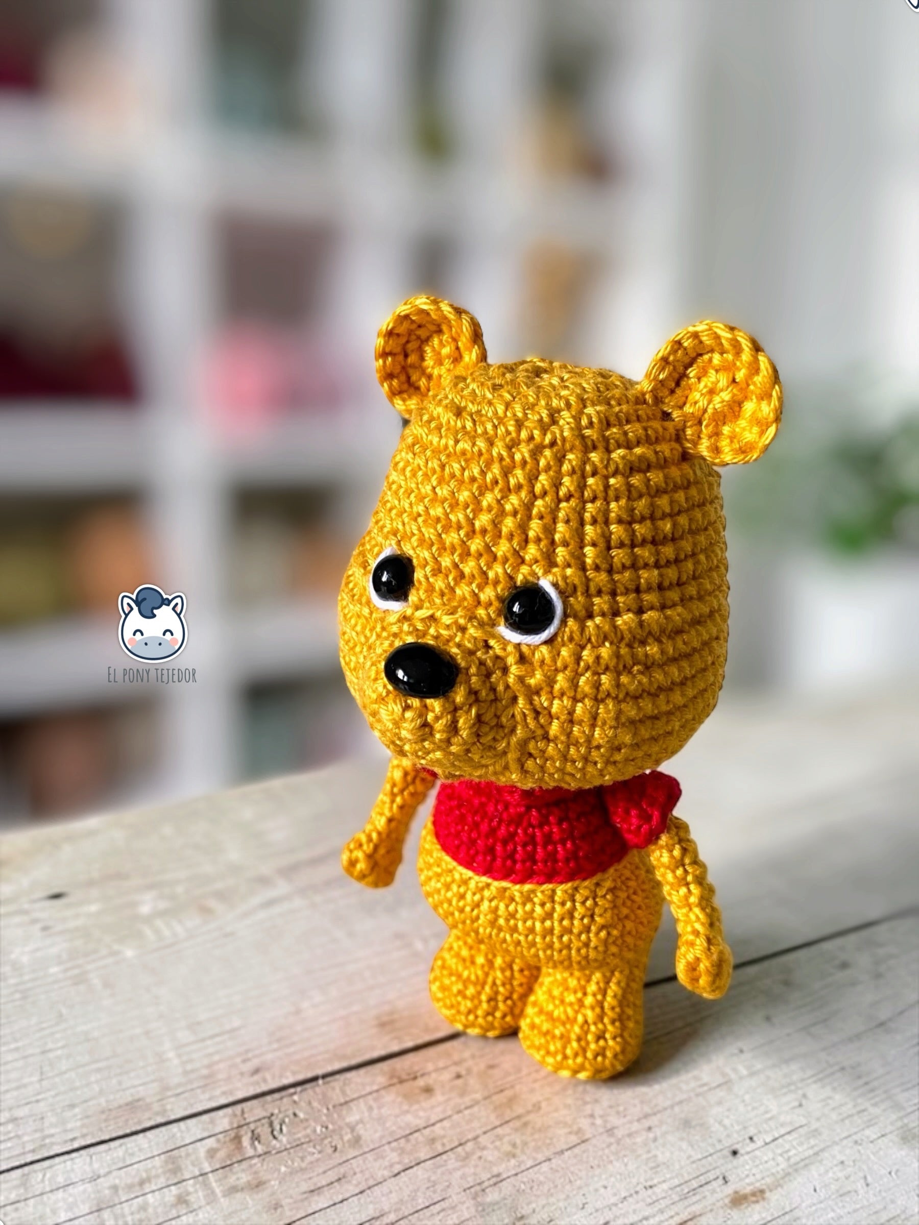 Patrón amigurumi inspirado en Winnie the Pooh tejido a crochet. Osito de ganchillo con camiseta roja, ideal para crear un adorable muñeco amigurumi con patrón PDF paso a paso.