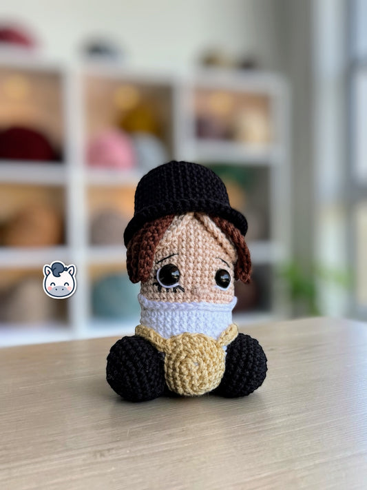 Muñeco amigurumi de Pene hecho a mano a crochet, inspirado en el personaje de La Naranja Mecánica. Peluche artesanal tejido con hilo de algodón, con sombrero negro y detalles característicos de la película. Ideal para coleccionistas de cine, decoración geek y amantes de las películas de culto.