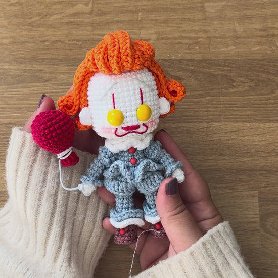 Amigurumi de Pennywise inspirado en IT, un patrón PDF de crochet con estilo Funko y su icónico globo rojo, perfecto para fans del cine de terror y la decoración de Halloween.