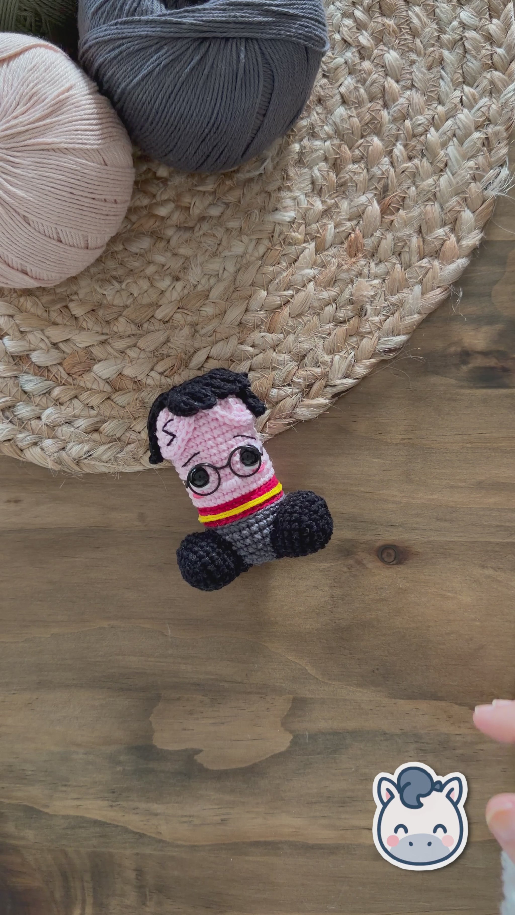 Patrón de ganchillo amigurumi pene inspirado en Harry Potter con gafas redondas, bufanda roja y amarilla y detalles bordados, diseño divertido y original.