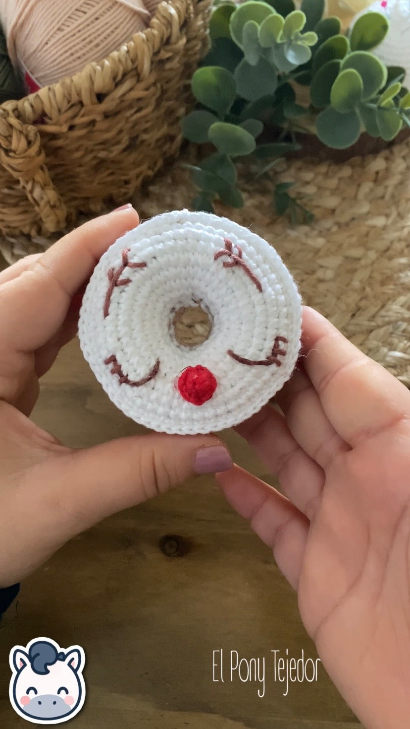 VIdeo Tutorial Patrón de ganchillo Amigurumi de dos donuts navideños: uno de color verde menta con un copo de nieve blanco y otro blanco con cara de reno y nariz roja.  Crochet Amigurumi pattern of two Christmas donuts: one mint green with a white snowflake and one white with a reindeer face and red nose.
